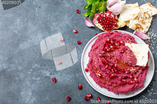 Image of Beet hummus dip with pita bread.