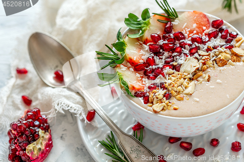 Image of Healthy smoothie bowl of strawberries, pomegranate and almonds.