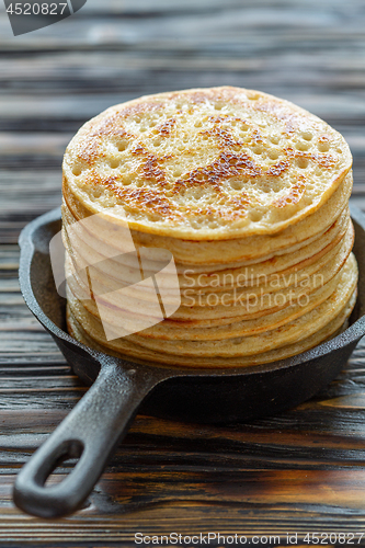 Image of Stack of pancakes in a cast iron pan.