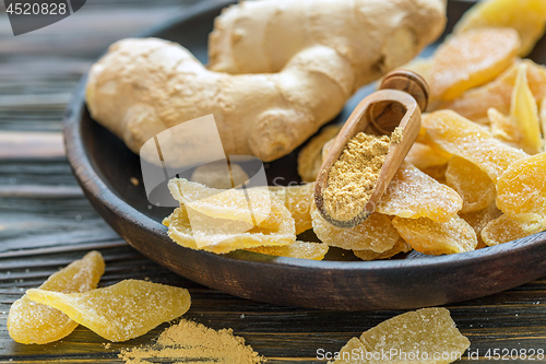 Image of Ginger root and candied ginger on a wooden plate.