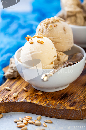 Image of Ice cream with seeds and halva in a white bowl.