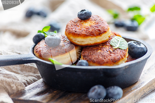 Image of Cheese pancakes and blueberries in cast iron pan.