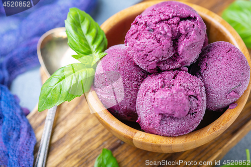 Image of Blueberry ice cream with green basil close-up.