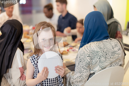 Image of cute little girl enjoying iftar dinner with family