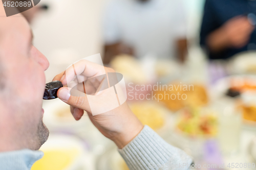 Image of modern multiethnic muslim family sharing a bowl of dates