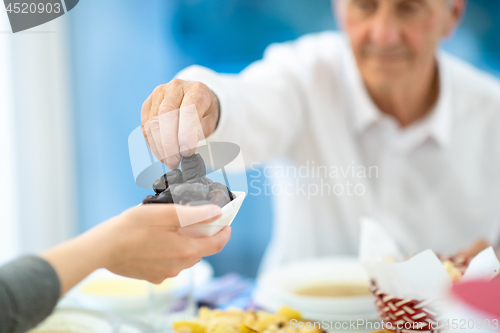 Image of modern multiethnic muslim family sharing a bowl of dates