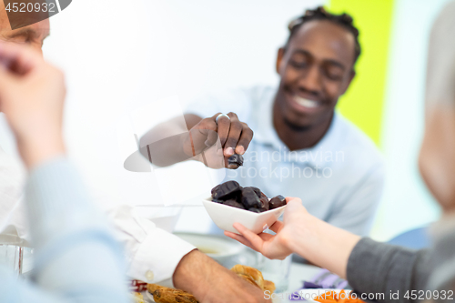 Image of modern multiethnic muslim family sharing a bowl of dates