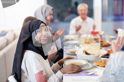 Image of black modern muslim woman enjoying iftar dinner with family