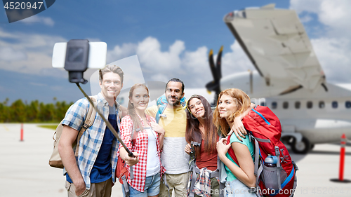 Image of friends taking selfie by smartphone on airfield