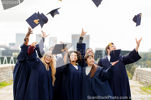 Image of happy graduates or students throwing mortar boards