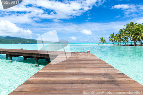 Image of wooden pier on tropical beach in french polynesia