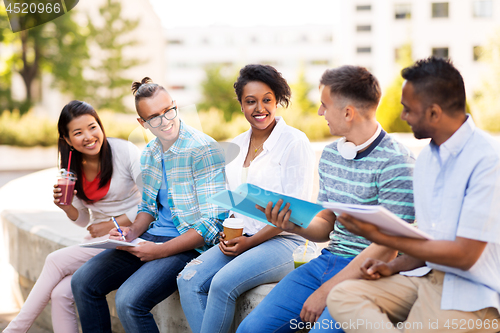 Image of students with notebook and takeaway drinks