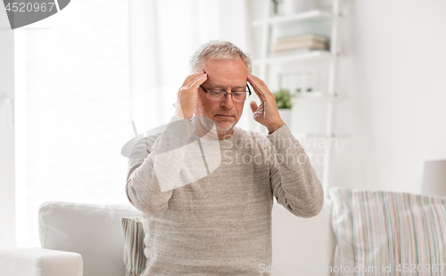 Image of senior man suffering from headache at home