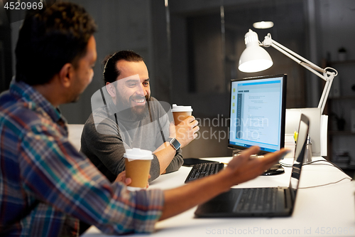 Image of creative team drinking coffee at night office