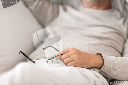 Image of close up of senior man with glasses sleeping