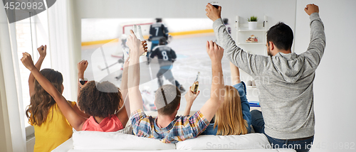 Image of friends watching ice hockey on projector screen