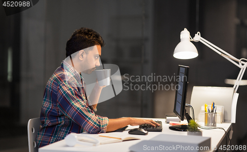 Image of creative man with computer working late at office