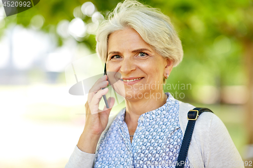 Image of senior woman calling on smartphone in summer