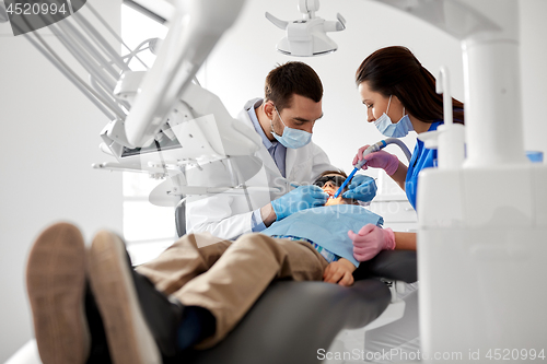 Image of dentist treating kid teeth at dental clinic