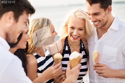 Image of happy friends in striped clothes eating ice cream