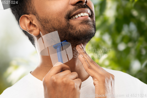 Image of close up of man shaving beard with razor blade