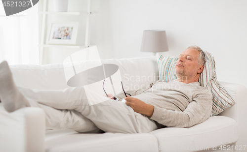Image of senior man sleeping on sofa at home