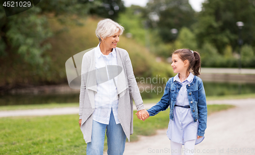 Image of grandmother and granddaughter walking at park