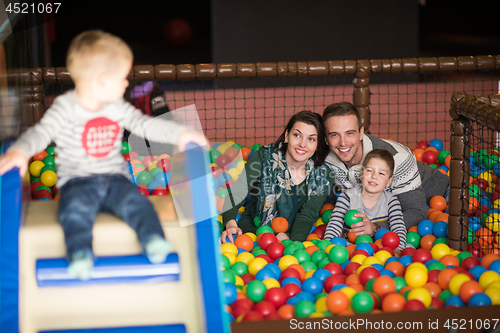 Image of young parents with kids in a children\'s playroom