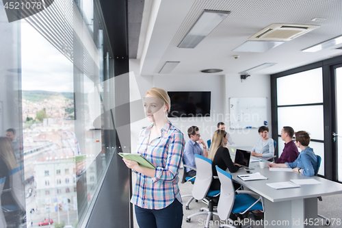 Image of Pretty Businesswoman Using Tablet In Office Building by window