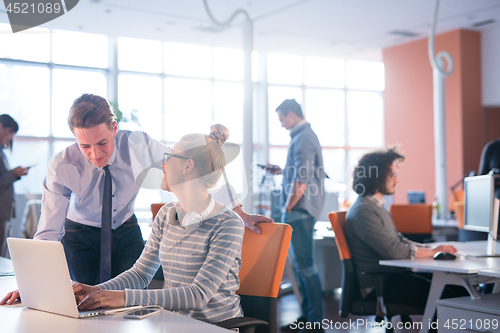 Image of Two Business People Working With laptop in office