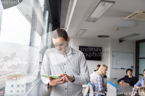 Image of Businessman Using Tablet In Office Building by window