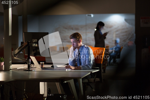 Image of man working on computer in dark office