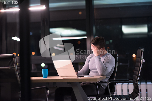 Image of man working on laptop in dark office