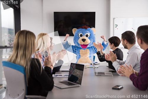 Image of boss dresed as bear having fun with business people in trendy of