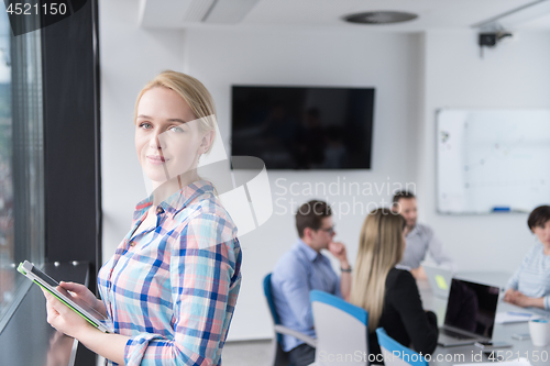 Image of Pretty Businesswoman Using Tablet In Office Building by window