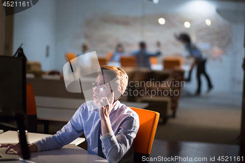 Image of man using mobile phone in dark office