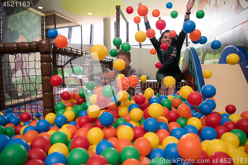 Image of Young mom with her kids in a children\'s playroom