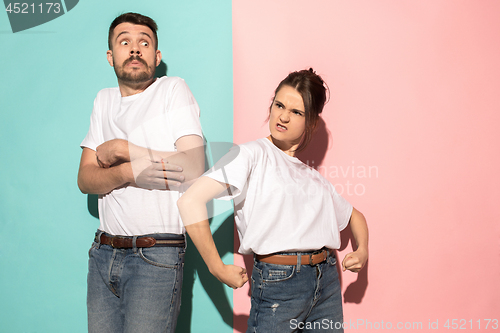 Image of The young emotional angry woman on pink studio background