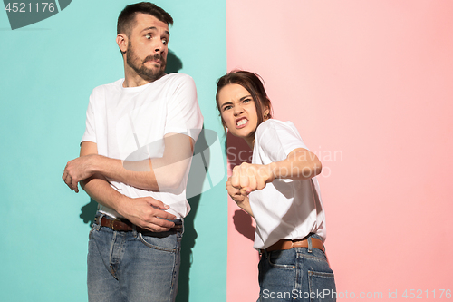 Image of The young emotional angry woman on pink studio background