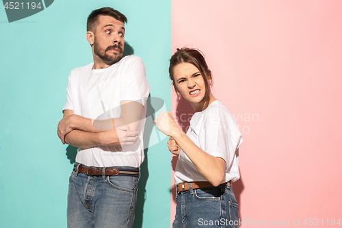 Image of The young emotional angry woman on pink studio background