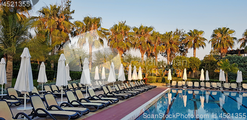 Image of Summer resort: swimming pool and chaise loungues