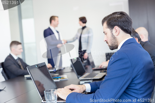 Image of Business people shaking hands in moder corporate office.