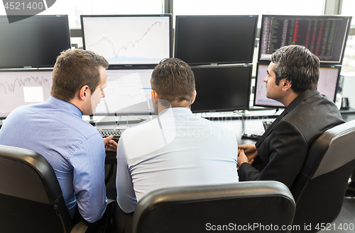 Image of Business team brainstorming while checking data at computer screens.