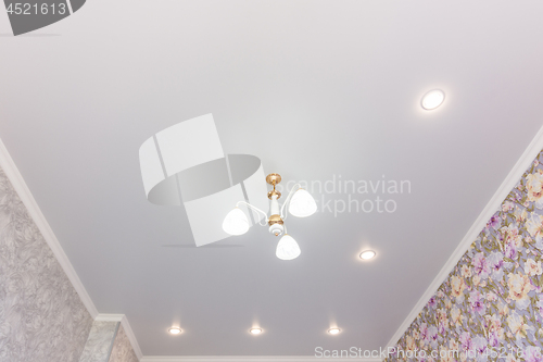 Image of Stretch ceiling in the room with a chandelier and spotlights