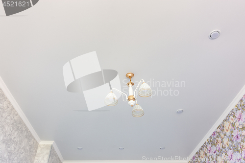 Image of Stretch matte ceiling in the room with a chandelier and spotlights, with natural light