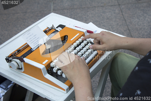 Image of Young man working on old vintage manual typewriter