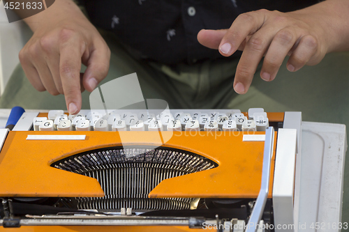 Image of Young man working on old vintage manual typewriter