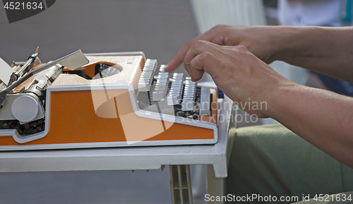 Image of Young man working on old vintage manual typewriter