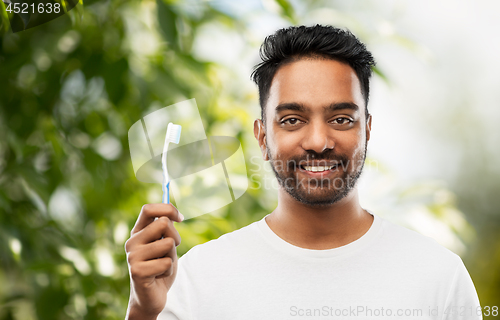 Image of indian man with toothbrush over natural background