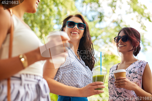 Image of happy women or friends with drinks at summer park